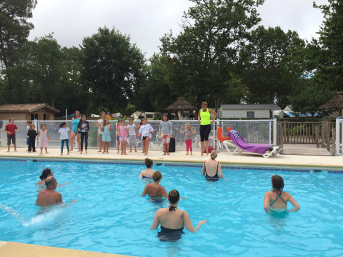 Kinder und Erwachsene nehmen an Poolaktivitäten im Flower Camping La Canadienne in Frankreich teil.
