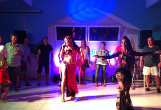 Holiday park guests enjoy a lively dance night with performers and audience at Flower Camping La Canadienne.