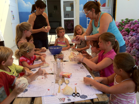 Kinderen en volwassenen doen een creatieve buitenactiviteit bij Flower Camping La Canadienne, Frankrijk.