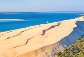 Vue spectaculaire sur la dune du Pilat près d'Arès, Nouvelle-Aquitaine, plage, forêt et océan Atlantique visibles.