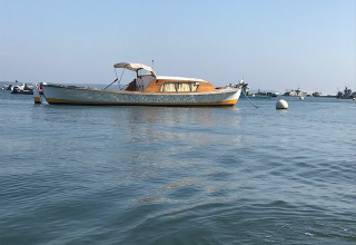Boot vor Anker im ruhigen Wasser bei Arès, Nouvelle-Aquitaine, Frankreich, mit anderen Booten dahinter.