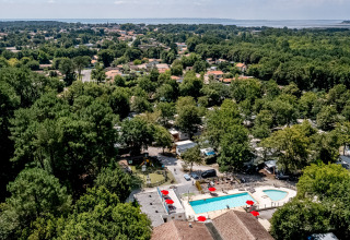 Vue aérienne du Flower Camping La Canadienne avec piscine et arbres en Nouvelle-Aquitaine, France.