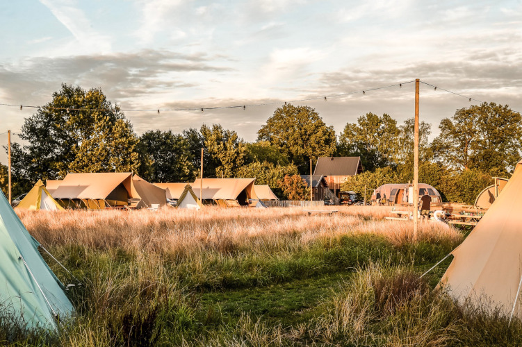 Blick auf Zelte und Natur auf dem Holiday Park Mölke in Overijssel, Niederlande, bei Sonnenuntergang.