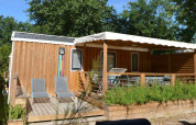 Buitenaanzicht van Stacaravan Premium Clim op Flower Camping La Canadienne, Frankrijk, met terrasstoelen.