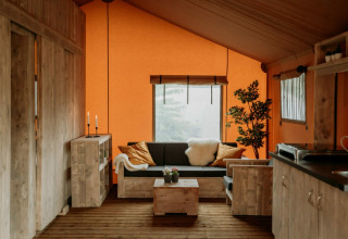 Et hyggeligt interiør fra Holiday Park Mölke med træmøbler, sofa og orange vægge i Overijssel, Holland.
