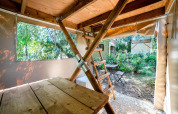 Blick in ein Safari-Zelt namens Airstay im Sivinos Camping Boutique Italien mit Holztisch und Gartenblick.