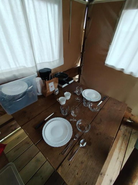 Houten tafel gedekt voor twee in Airstay safaritent bij Sivinos Camping Boutique, Italië.