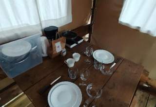 Houten tafel gedekt voor twee in Airstay safaritent bij Sivinos Camping Boutique, Italië.