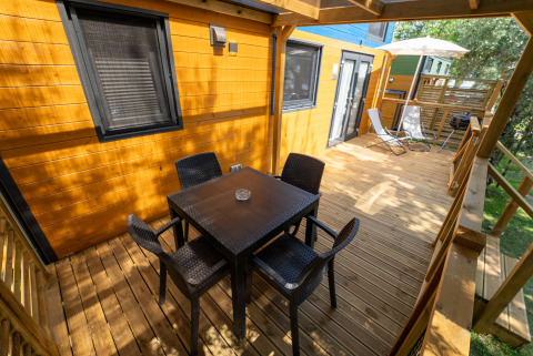 Buitenterras in hout bij Tiny House Sivinos Camping Boutique in Italië met tafel en stoelen.