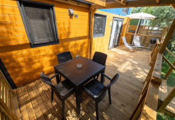 Houten terras bij Tiny House Sivinos Camping Boutique in Italië met eettafel en loungestoelen.