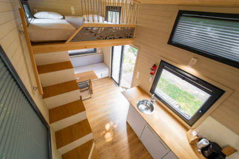 Moderne tiny house met mezzanine, keuken en leefruimte bij Sivinos Camping Boutique, Italië.
