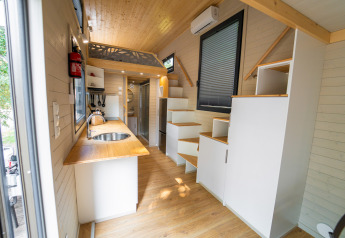 Modern tiny house interieur bij Sivinos Camping Boutique in Italië met loft en compacte keuken.