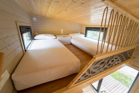 Slaaploft met twee bedden in Tiny House bij Sivinos Camping Boutique in Italië, houten afwerking.