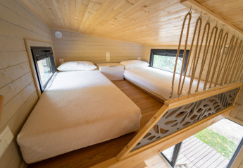 Slaapvide met twee bedden in Tiny House bij Sivinos Camping Boutique in Italië, lichte houtafwerking.