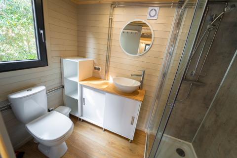 Moderne badkamer in een tiny house bij Sivinos Camping Boutique in Italië, met houten accenten en douche.