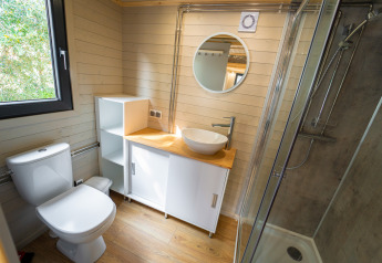 Moderne badkamer in een tiny house bij Sivinos Camping Boutique in Italië, met hout en een douche.