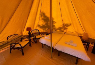 Indretning af Bell Tent på Sivinos Camping Boutique i Italien med dobbeltseng og komfortable møbler.