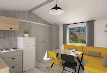 Moderne Glamping-Unterkunft mit Küchenzeile, gelber Eckbank, Esstisch und großem Fenster.