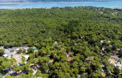 Aerial view of Flower Camping Monplaisir in Nouvelle-Aquitaine, France, surrounded by forest and near the sea.