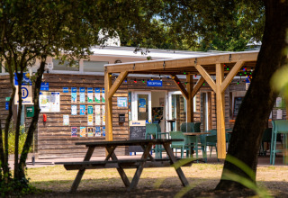Recepción y zona de mesas al aire libre en Flower Camping Monplaisir en Nouvelle-Aquitaine, Francia.