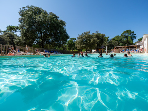 Udendørs swimmingpool med badegæster og solsenge på Flower Camping Monplaisir i Nouvelle-Aquitaine, Frankrig.