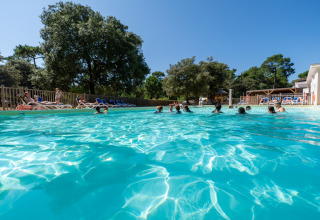 Piscina all'aperto con persone che si rilassano al Flower Camping Monplaisir in Nouvelle-Aquitaine, Francia.