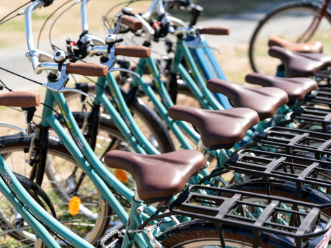 Rij turquoise fietsen met bruine zadels bij Flower Camping Monplaisir in Nouvelle-Aquitaine, Frankrijk.