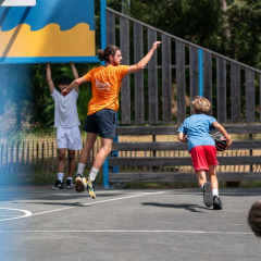 Niños y adultos juegan baloncesto al aire libre en Flower Camping Monplaisir en Nueva Aquitania, Francia.