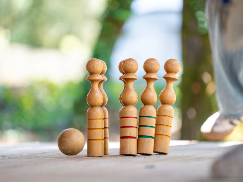 Houten kegels en bal buiten op tafel op Flower Camping Monplaisir in Nouvelle-Aquitaine, Frankrijk.