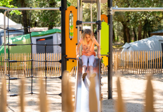 Child plays on a slide at the playground of Flower Camping Monplaisir, Nouvelle-Aquitaine, France.