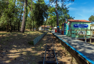 Smalsporet jernbanestation ved Saint-Trojan-les-Bains omgivet af træer i Flower Camping Monplaisir, Frankrig.