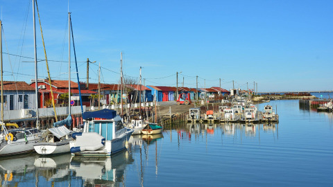 Barcos y coloridas casetas en el puerto de Saint-Trojan-les-Bains, en la isla de Oléron, Nouvelle-Aquitaine, Francia.