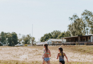 Twee kinderen rennen op een steiger bij het water in het vakantiepark Wilsumer Berge, Duitsland.