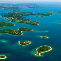 Luftfoto af øgruppen nær Pomer i Istrien, Kroatien, omgivet af det smukke, blå Adriaterhav.