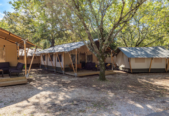 Safarizelt Lodge auf Camping Cikat in Kroatien, umgeben von Bäumen und gemütlichen Sitzbereichen.