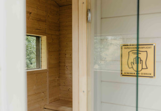 Ingang tot een moderne houten sauna, gezien vanaf de deur van een tiny house op Wilsumer Berge, Duitsland.
