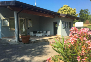 Entrée de Sivinos Camping Boutique en Lombardie, Italie, avec des fleurs et un espace salon extérieur.