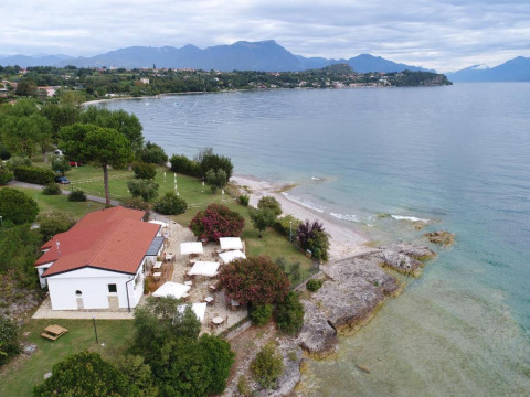 Vista aerea di Sivinos Camping Boutique in Lombardia, Italia, affacciato sul Lago di Garda e le montagne.