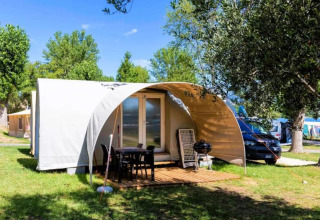 Modern glampingtent met terras en tuinstoelen op Sivinos Camping Boutique in Lombardije, Italië.