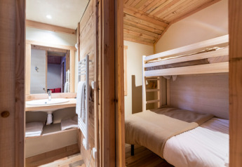 Et kig ind i Chalet Montana Vista på Les Chalets Huttopia Champagny en Vanoise med køjeseng og badeværelse.
