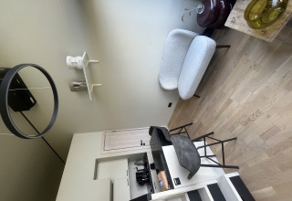 Sala moderna en una tiny house con sofá, barra y cocina en Holiday Park Eigen Wijze, Países Bajos.