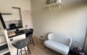 Petit salon moderne avec canapé, chaises hautes et kitchenette au Holiday Park Eigen Wijze, Pays-Bas.