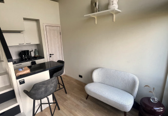 Modernes Tiny House mit Küche, Barhockern und gemütlicher Sitzecke im Holiday Park Eigen Wijze, Niederlande.