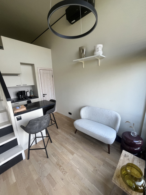 Moderne lille stue med sofa, barstole og køkken i Tiny house på Holiday park Eigen Wijze, Holland.