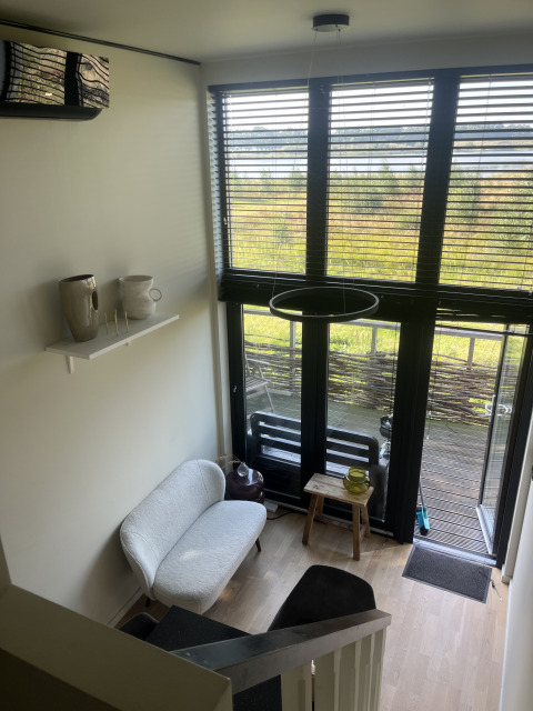 Lille, moderne stue i et tiny house på Holiday park Eigen Wijze i Holland, lyst og stilrent indrettet.