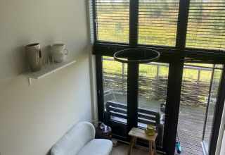 Lille, moderne stue i et tiny house på Holiday park Eigen Wijze i Holland, lyst og stilrent indrettet.