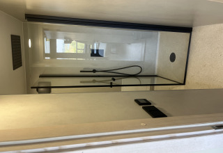 Moderne douche in een tiny house bij Holiday park Eigen Wijze in Nederland, gezien vanaf de deur.
