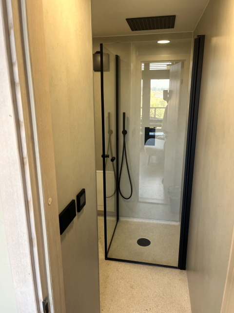 Moderne Dusche in einem Tiny House im Holiday Park Eigen Wijze in den Niederlanden, von der Tür aus gesehen.