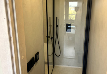 Moderne Dusche in einem Tiny House im Holiday Park Eigen Wijze in den Niederlanden, von der Tür aus gesehen.