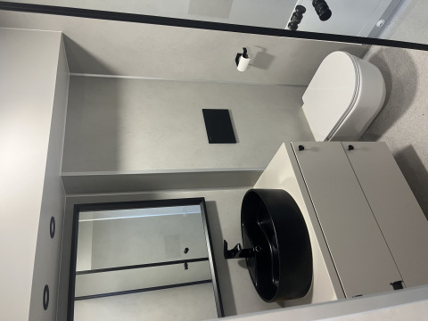 Bagno moderno in una tiny house presso Holiday park Eigen Wijze, Paesi Bassi, con lavabo nero.